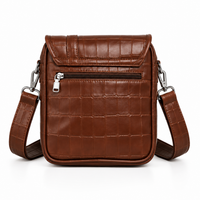 Brown crocodile-textured sling bag angled view