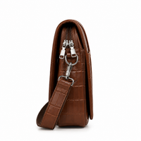 Brown crocodile-textured sling bag side profile